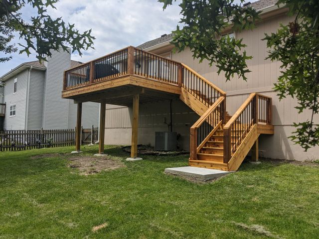 Elevated cedar deck with wood railing and a staircase