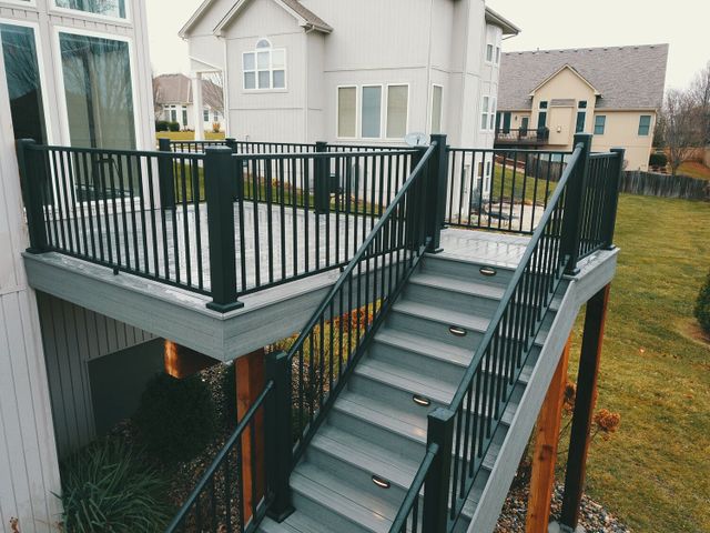 Elevated composite deck with black metal railing and stairs
